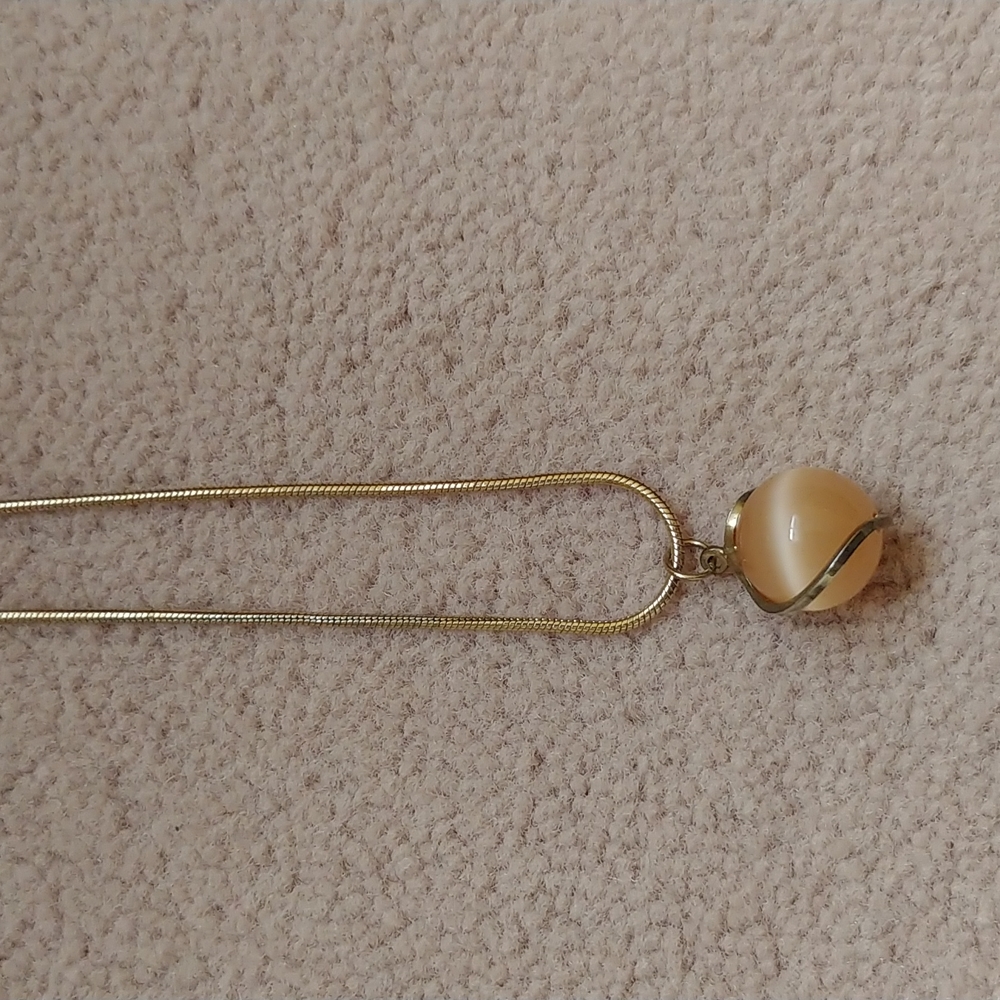 Orange orb necklace on a gold chain